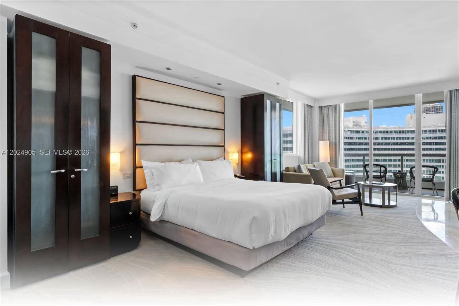 A modern bedroom features a king bed, built-in wardrobes, and a balcony with city views — 4391 Collins Ave # 1001, Miami Beach FL 33140, MIAMI BEACH, FL