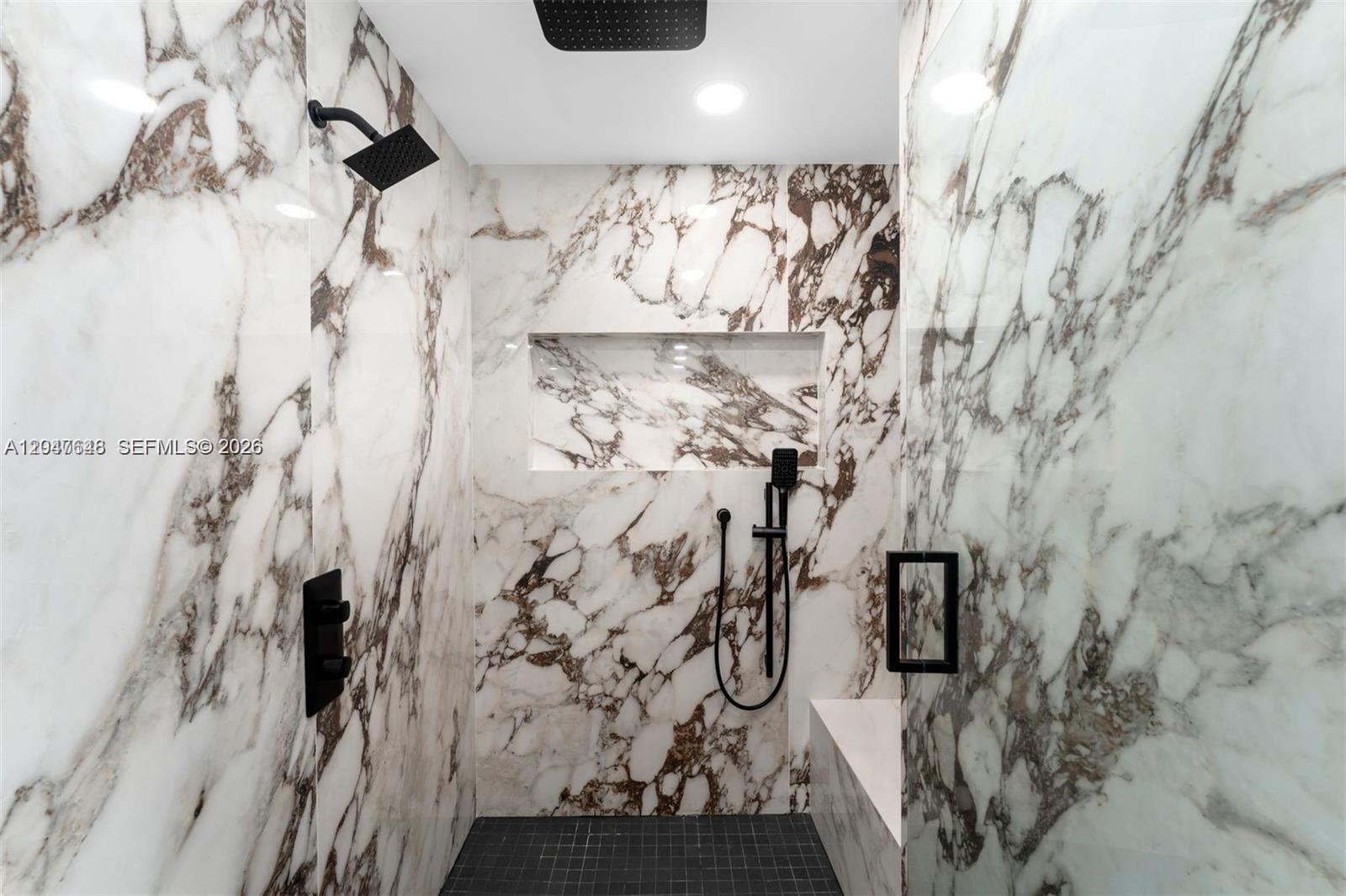 A walk-in shower features marble-patterned walls, a black grid floor, and matte black fixtures — 900 Biscayne Blvd # 4202, Miami FL 33132, MIAMI, FL