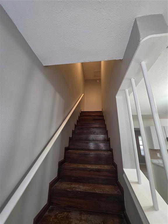 A staircase with dark wood treads leads upward between gray walls and a white railing — 11038 REGENCY COMMONS COURT, ORLANDO, FL