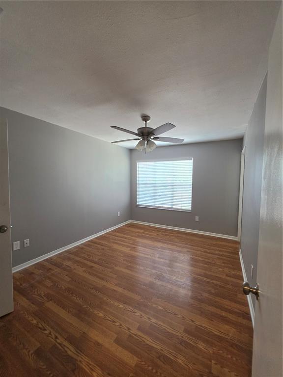 An empty bedroom with gray walls, wood-look flooring, a ceiling fan, and a window with blinds — 11038 REGENCY COMMONS COURT, ORLANDO, FL