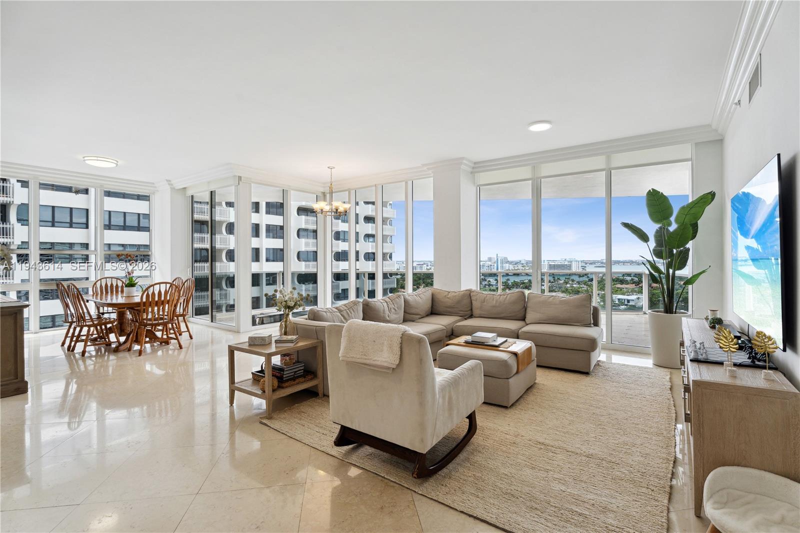 A bright living and dining area features floor-to-ceiling windows, tile flooring, and a sectional sofa — 10225 Collins Ave # 904, Bal Harbour FL 33154, BAL HARBOUR, FL
