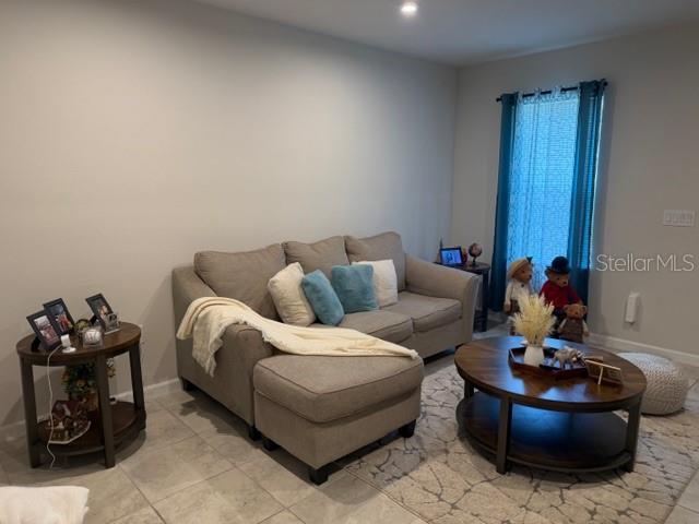 A living room features a beige sectional sofa, a round wooden coffee table, and a side table — 12250 GRIZZLY LANE, NEW PORT RICHEY, FL