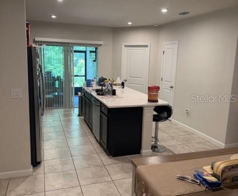 A kitchen features a dark island with a white countertop and a sliding glass door — 12250 GRIZZLY LANE, NEW PORT RICHEY, FL