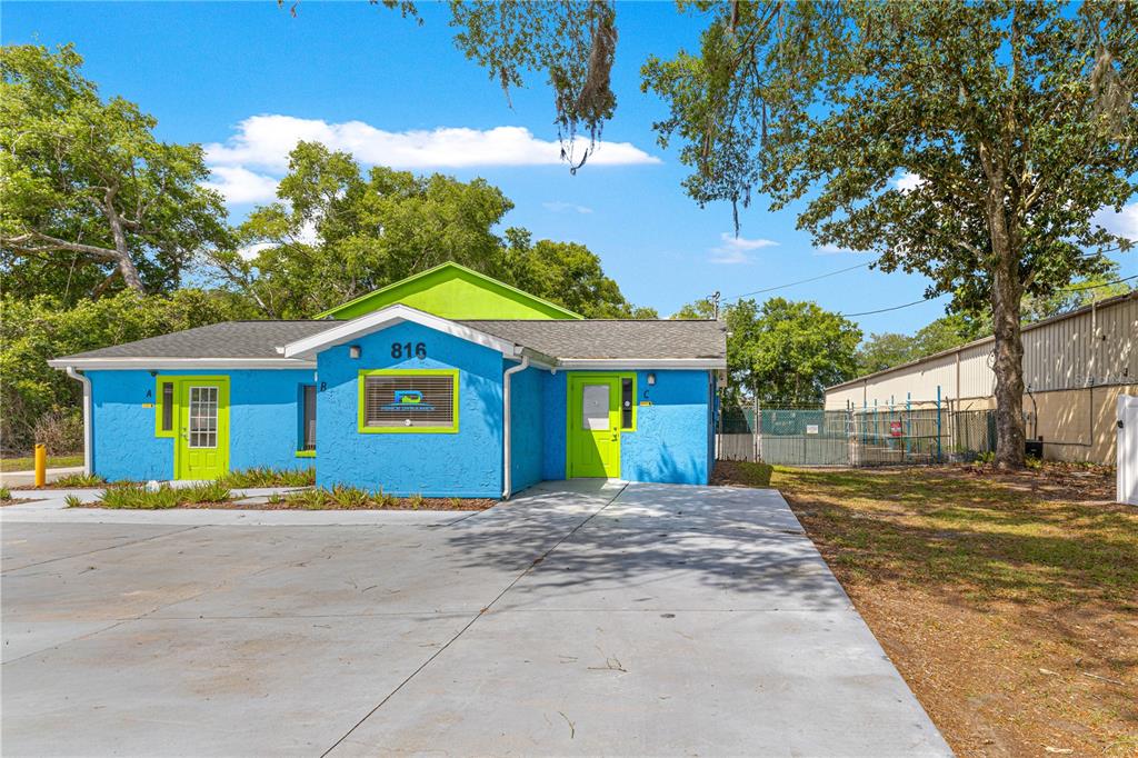 A bright blue commercial building with lime green trim and three separate entrance doors — 816 NW 30TH AVENUE, OCALA, FL