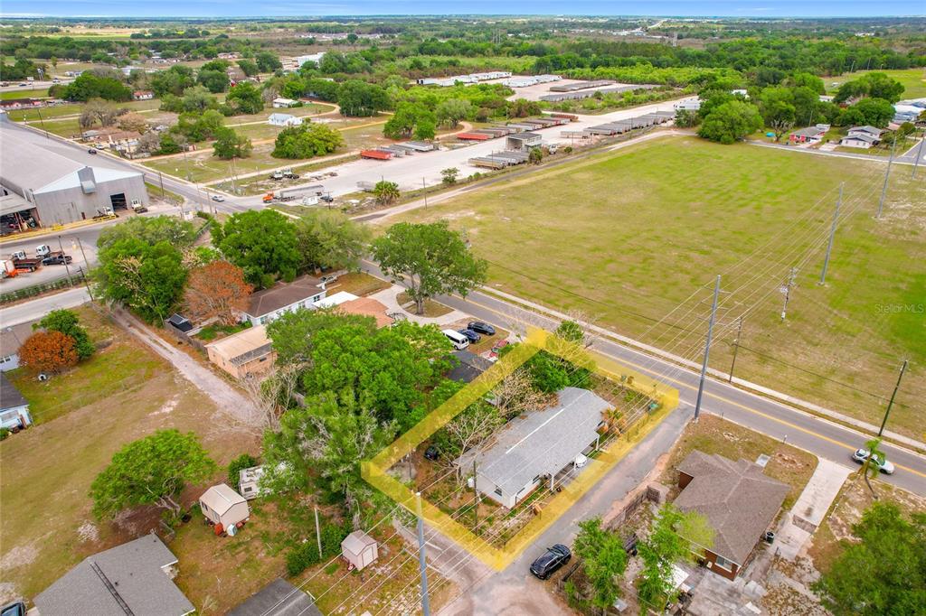 An aerial view shows a single-story house with a grey roof surrounded by trees — 627 WASHINGTON AVENUE, LAKE WALES, FL