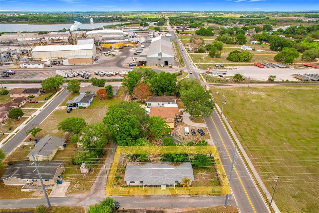 An aerial view shows a single-story house highlighted by a yellow border near a road — 627 WASHINGTON AVENUE, LAKE WALES, FL