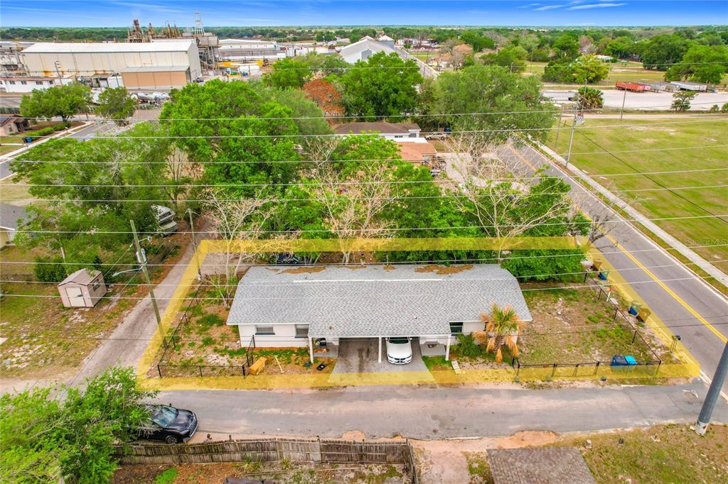 An aerial view shows a single-story house with a gray roof and a fenced yard — 627 WASHINGTON AVENUE, LAKE WALES, FL