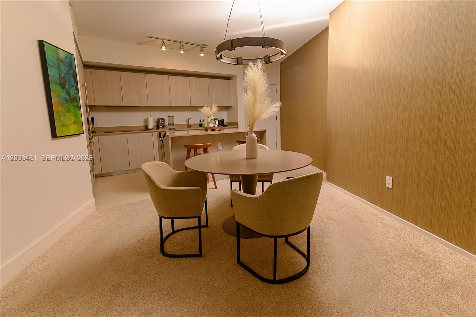 A dining area with a round table and chairs sits adjacent to a modern kitchen — 4111 S Ocean Dr # 1710, Hollywood FL 33019, HOLLYWOOD, FL