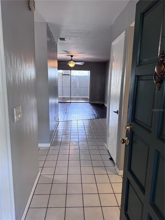 An entryway with white tile flooring leads to a living area with dark wood floors — 1201 N MCMULLEN BOOTH ROAD, CLEARWATER, FL