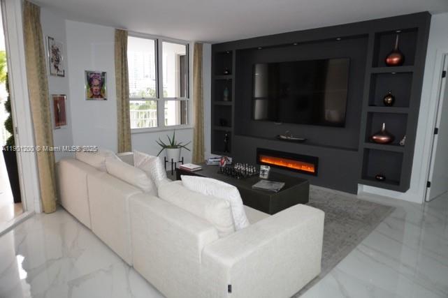 A modern living room features a white sectional sofa facing a dark built-in media wall — 701 Brickell Key Blvd # 412, Miami FL 33131, MIAMI, FL