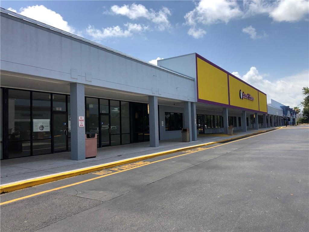 A view of a commercial strip mall exterior with a Planet Fitness storefront — 1861 N HIGHLAND AVENUE, CLEARWATER, FL