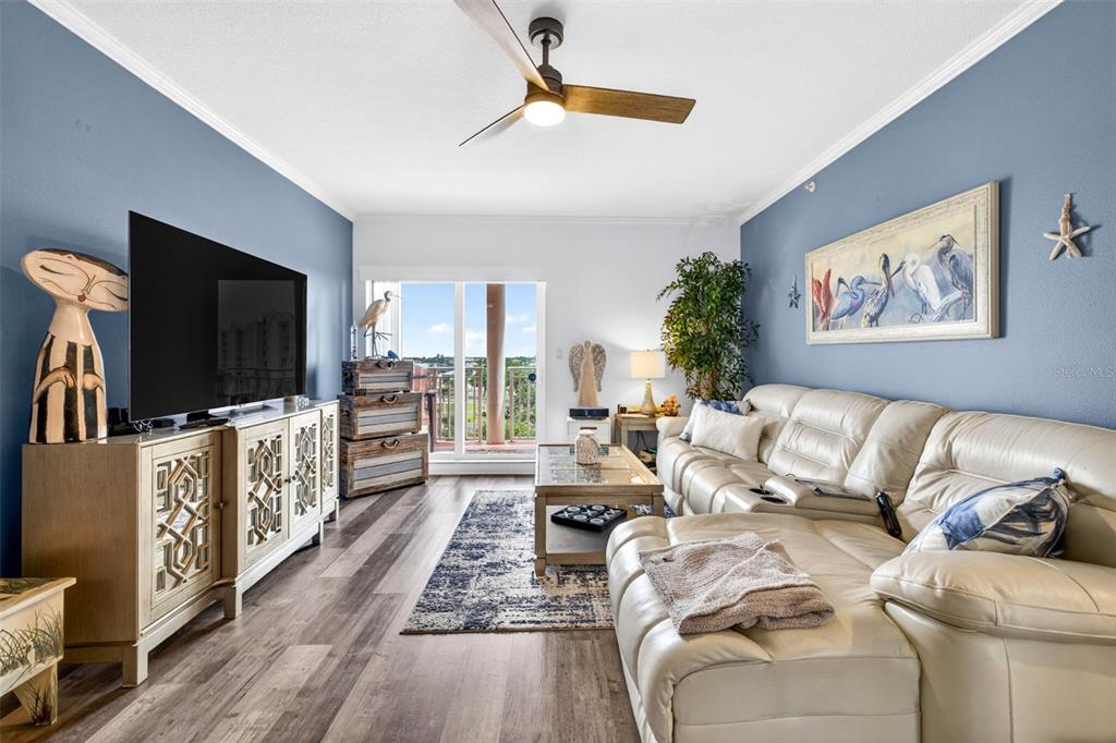 A living room features blue walls, a white leather sectional, and a television console — 4516 SEAGULL DRIVE UNIT 615, NEW PORT RICHEY, FL