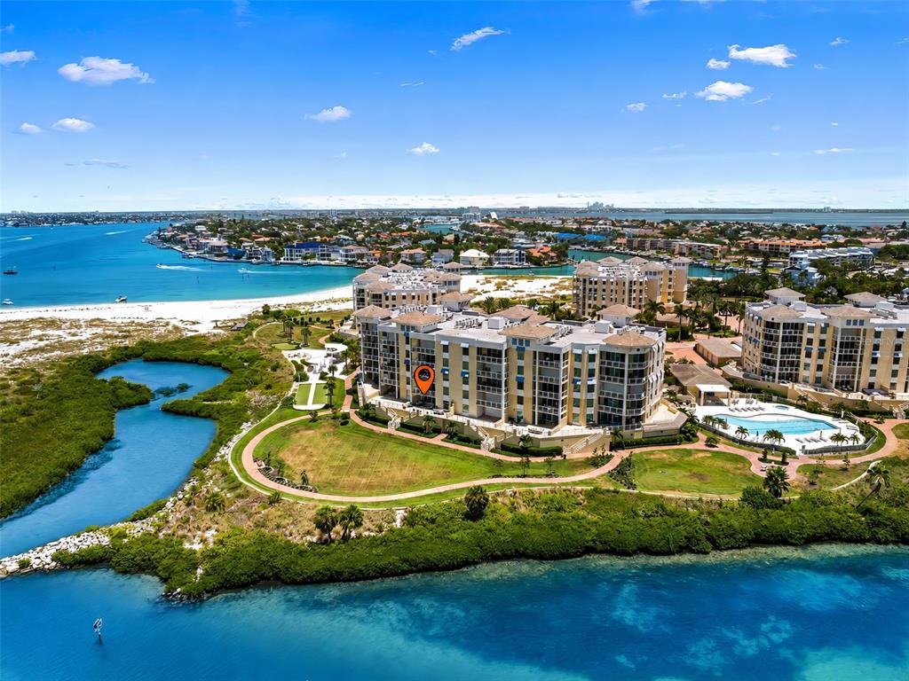 An aerial view of a multi-story waterfront condominium complex surrounded by coastal vegetation and water — 795 COLLANY ROAD UNIT 204, TIERRA VERDE, FL