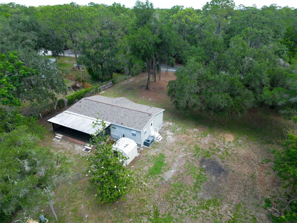 An aerial view shows a single-story house with a screened porch and a detached shed — 1819 SINCLAIR HILLS ROAD, LUTZ, FL