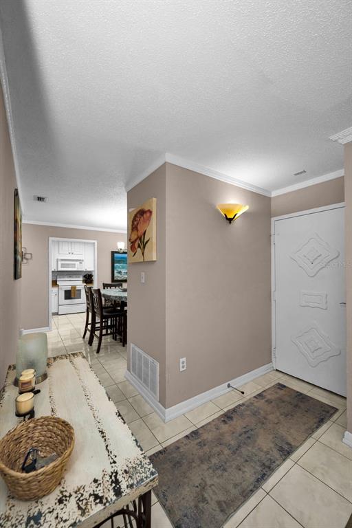 An entryway with tile flooring leads to a dining area and kitchen — 2700 BAYSHORE BOULEVARD UNIT 2205, DUNEDIN, FL