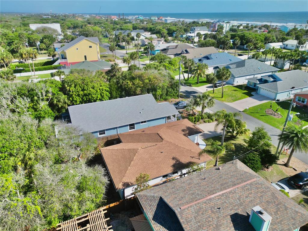 An aerial view shows several residential houses with shingled roofs surrounded by trees and vegetation — 1624 S DAYTONA AVENUE, FLAGLER BEACH, FL