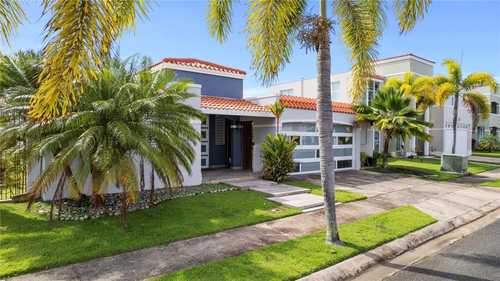 A modern house with a blue facade, red tile roof, and a palm-lined front yard — Estancias De Cerro Grodo CALLE PLAZA FABIAN UNIT 63, VEGA ALTA, PR