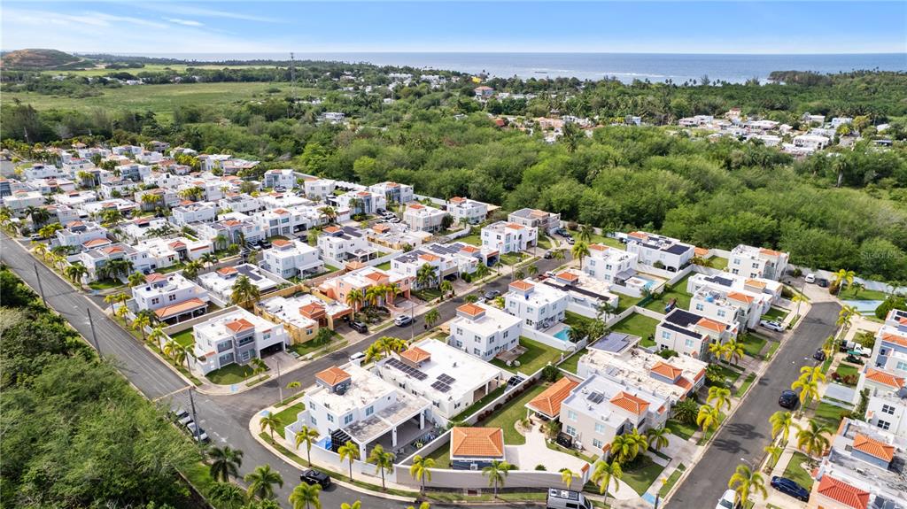 An aerial view shows a residential neighborhood with white houses and palm trees near the coast — Estancias De Cerro Grodo CALLE PLAZA FABIAN UNIT 63, VEGA ALTA, PR