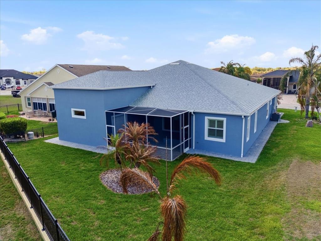An aerial view of a blue house with a screened-in patio and a fenced yard — 517 HOME COMING WAY, POLK CITY, FL