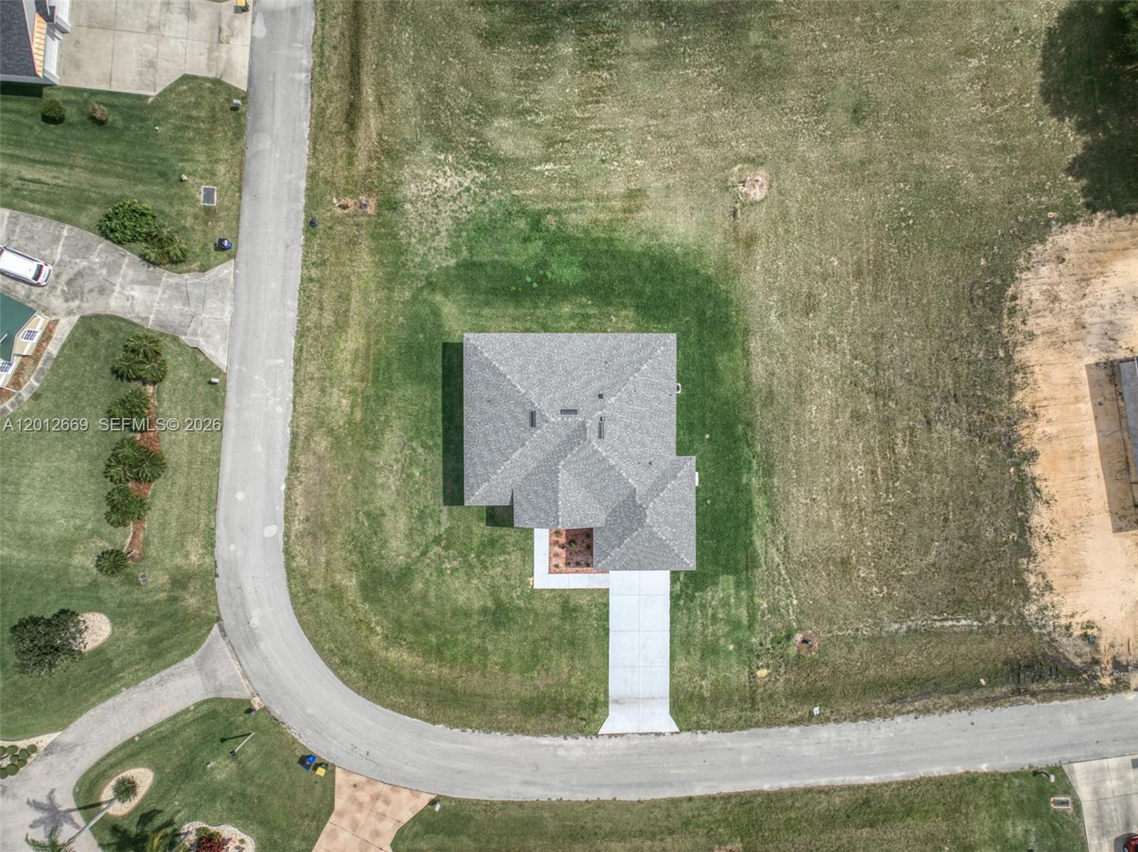 An aerial view shows a house with a gray roof situated on a large lot — 1025 Greenway Ter # 1025, Sebring FL 33876, SEBRING, FL