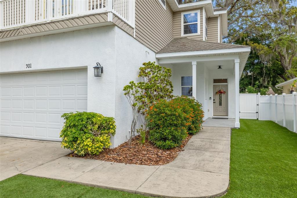 A two-story house exterior features a white garage, a front entrance, and a green lawn — 901 VIRGINIA AVENUE, TARPON SPRINGS, FL