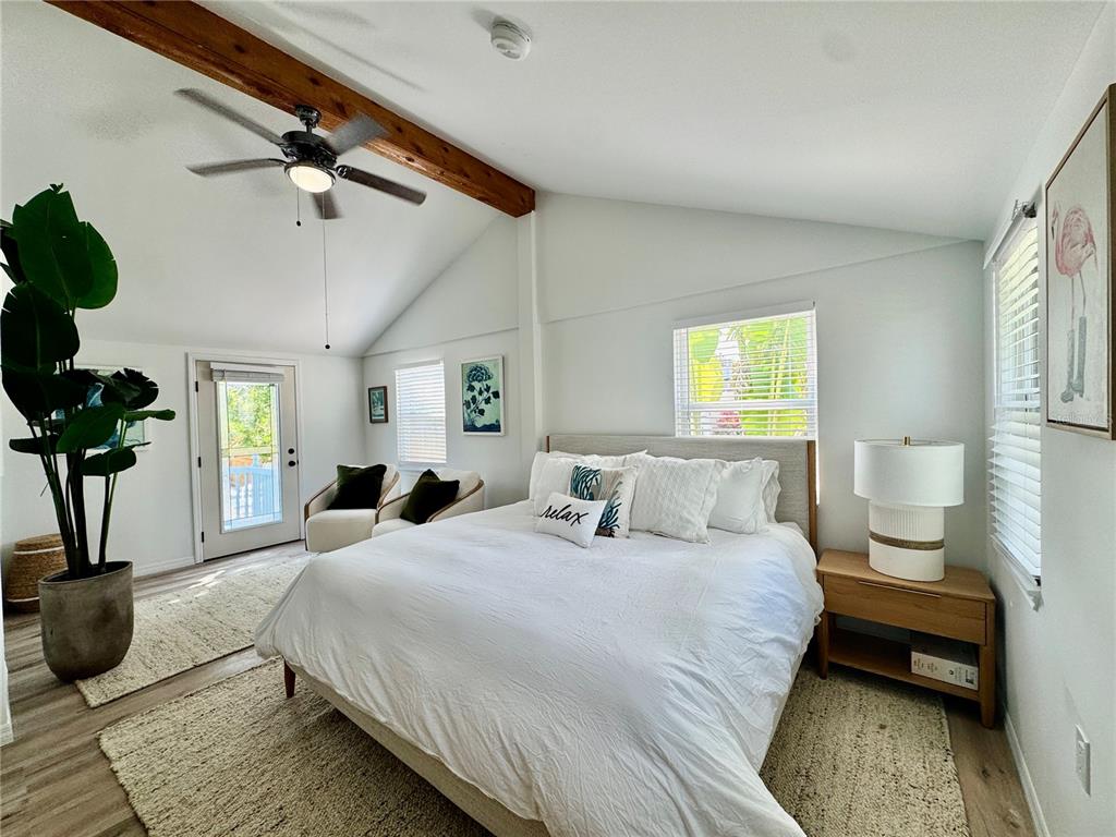 A bedroom features a vaulted ceiling with a wooden beam, a ceiling fan, and a bed — 6980 POINSETTA, LONGBOAT KEY, FL