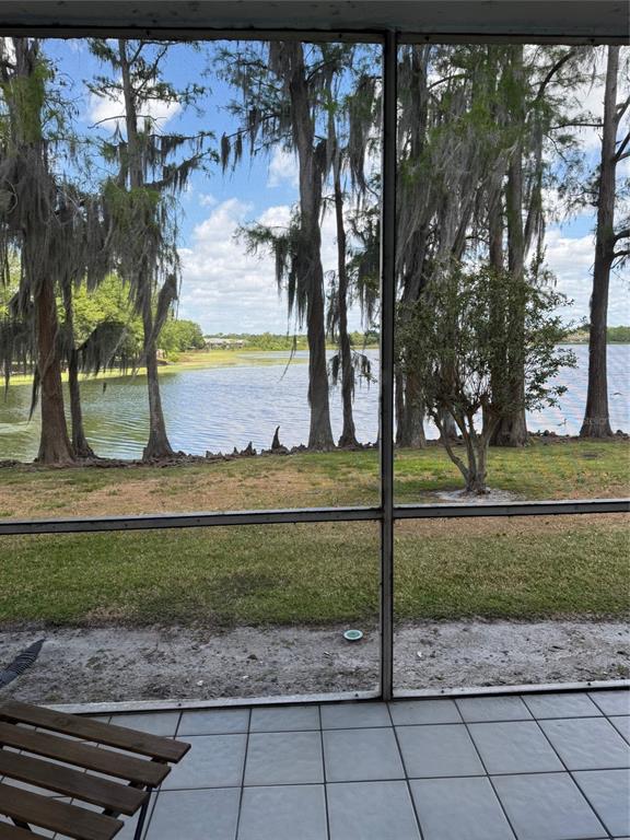 A view of a lake and trees from a tiled, screened-in porch — 2225 HOLDEN AVENUE UNIT 104, ORLANDO, FL