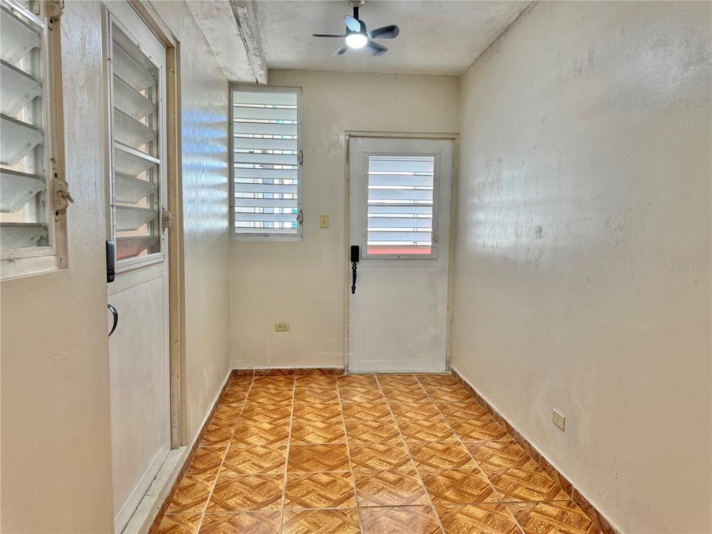 A kitchen features white cabinets, a stainless steel refrigerator, a gas cooktop, and patterned wallpaper — PASEO MAGDALENA ST. URB. LEVITTOWN LAKES UNIT 11-AK, TOA BAJA, PR