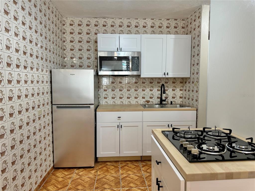 A small bathroom features white tiled walls, a black vanity, and a walk-in shower — PASEO MAGDALENA ST. URB. LEVITTOWN LAKES UNIT 11-AK, TOA BAJA, PR