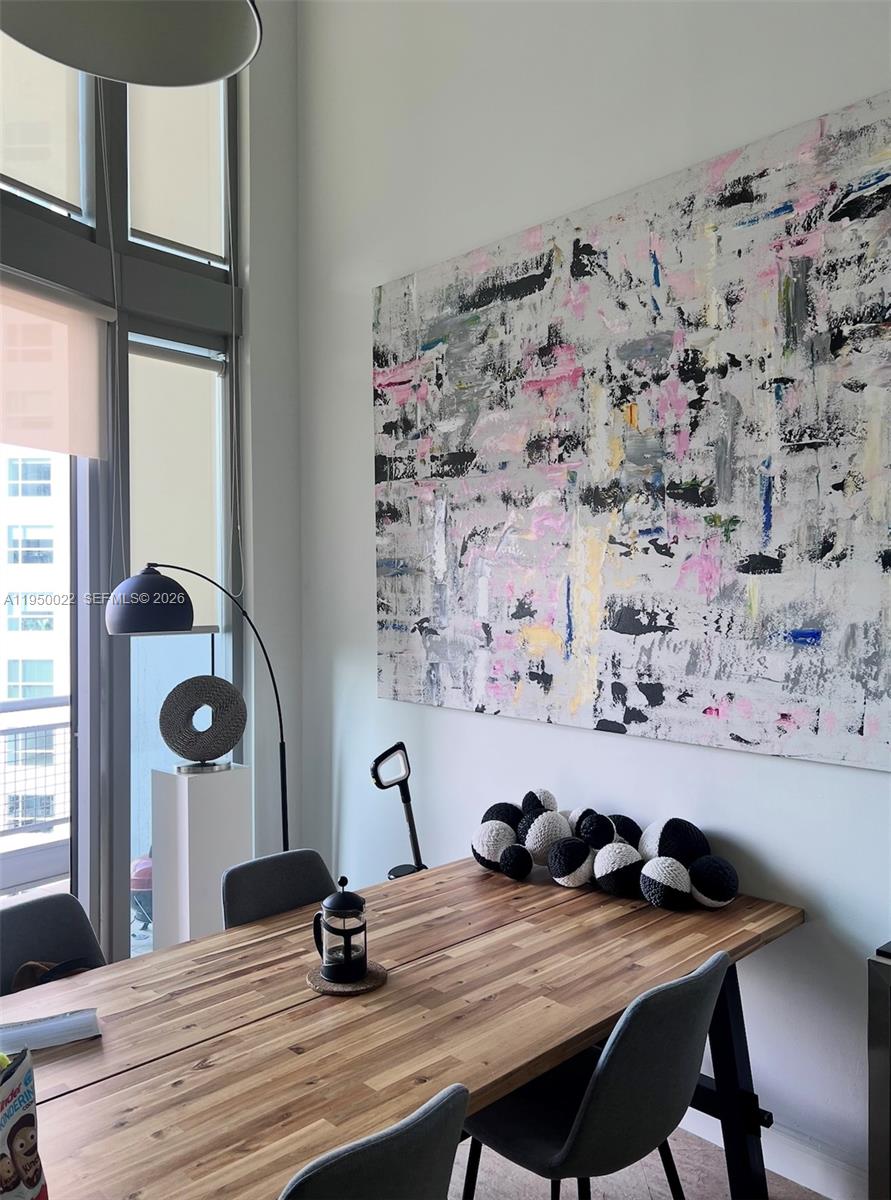 A dining room features a wooden table, grey chairs, and a large abstract painting — 690 SW 1st Ct # 2134, Miami FL 33130, MIAMI, FL