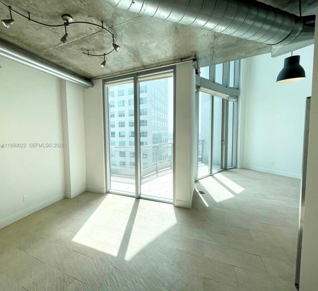 A modern room features concrete ceilings, exposed ductwork, tile floors, and floor-to-ceiling glass doors — 690 SW 1st Ct # 2134, Miami FL 33130, MIAMI, FL