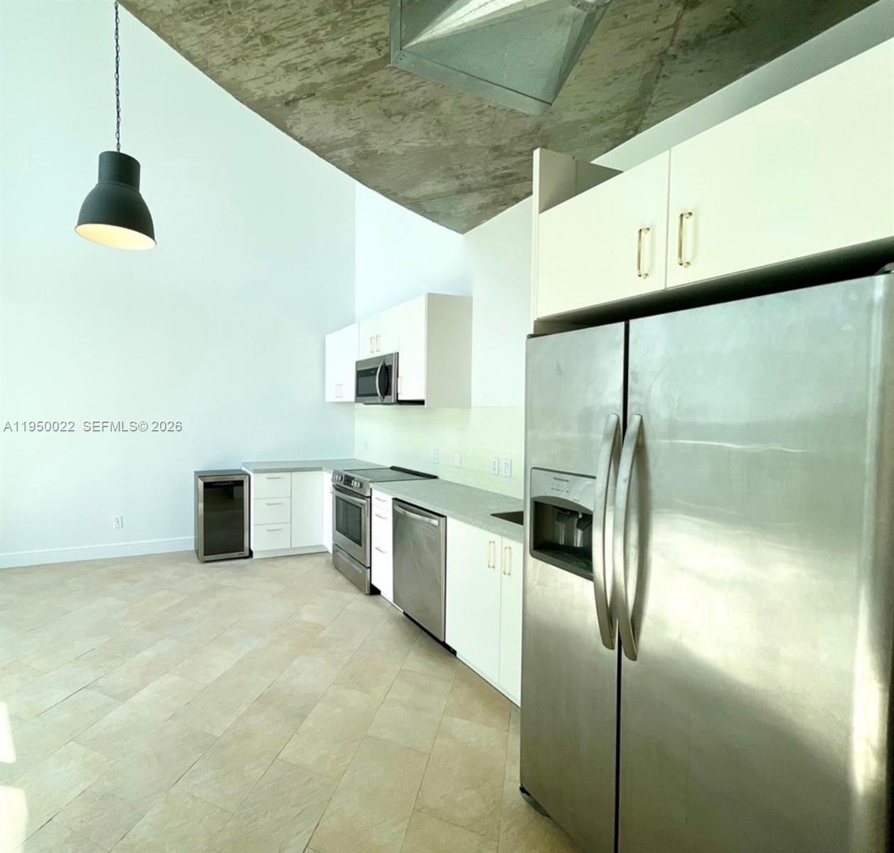 A modern kitchen features white cabinetry, stainless steel appliances, and a high, exposed concrete ceiling — 690 SW 1st Ct # 2134, Miami FL 33130, MIAMI, FL
