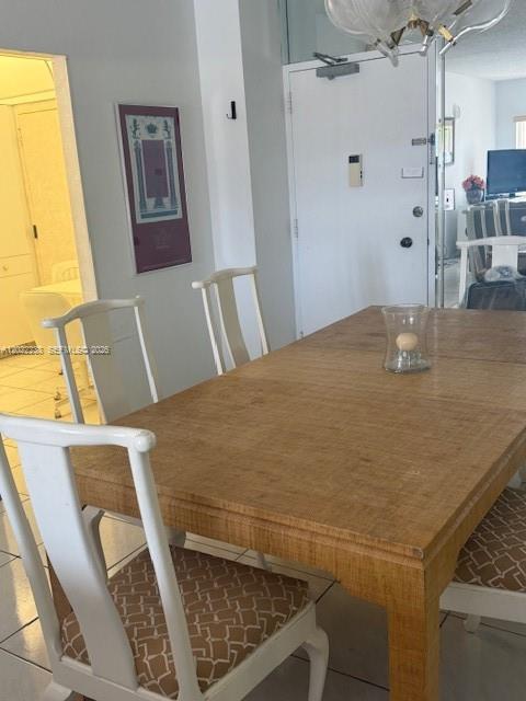 A dining room features a light wood table and white chairs with patterned cushions — 1965 S Ocean Dr # 9K, Hallandale Beach FL 33009, HALLANDALE BEACH, FL