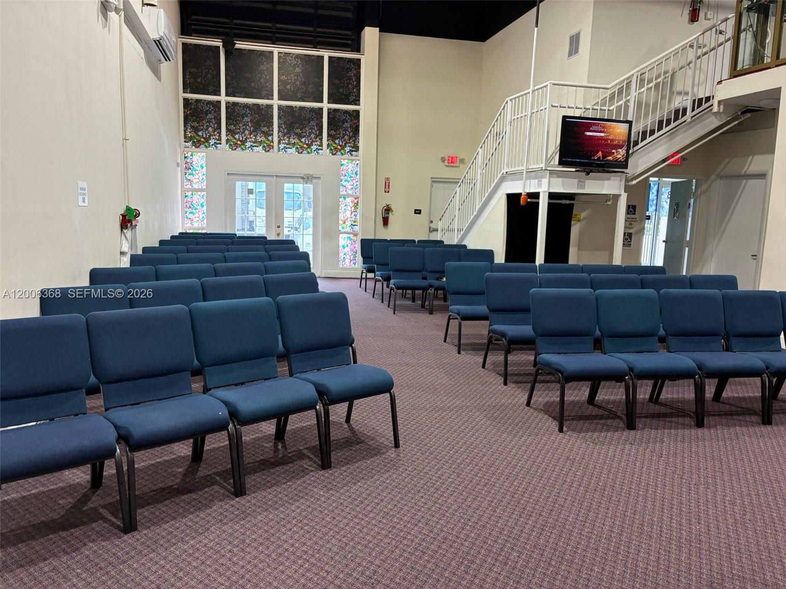 A room with rows of blue chairs, a staircase, and stained glass windows — 5993 NW 102nd Ave # 7, Doral FL 33178, DORAL, FL