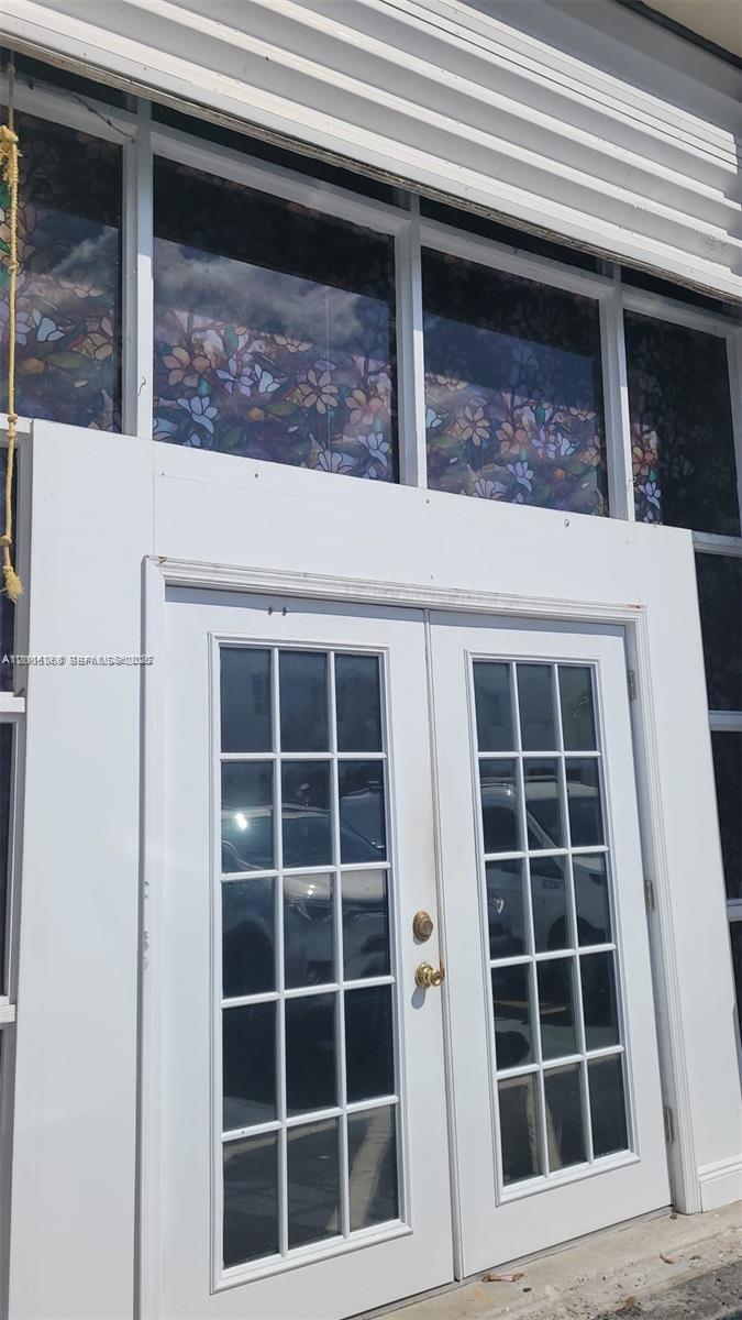 A white double door with glass panes sits beneath a row of floral stained-glass windows — 5993 NW 102nd Ave # 7, Doral FL 33178, DORAL, FL