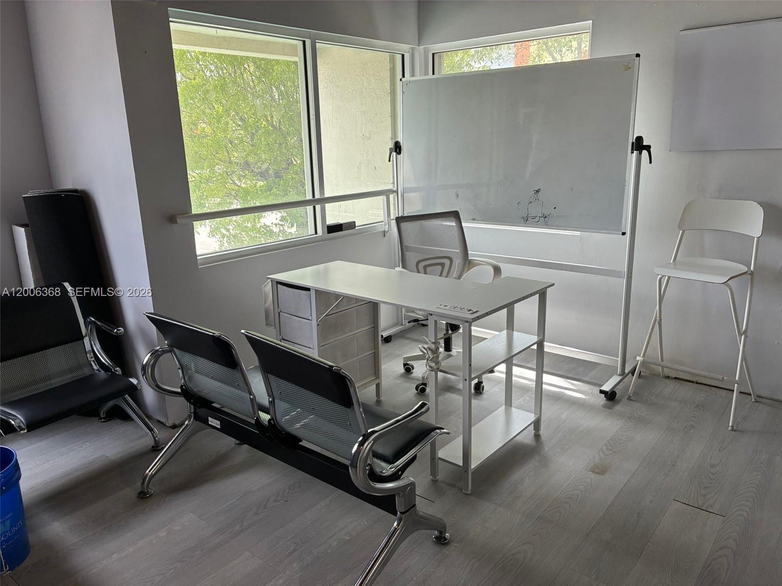 An office room features a desk, chairs, a rolling whiteboard, and large windows — 5993 NW 102nd Ave # 7, Doral FL 33178, DORAL, FL