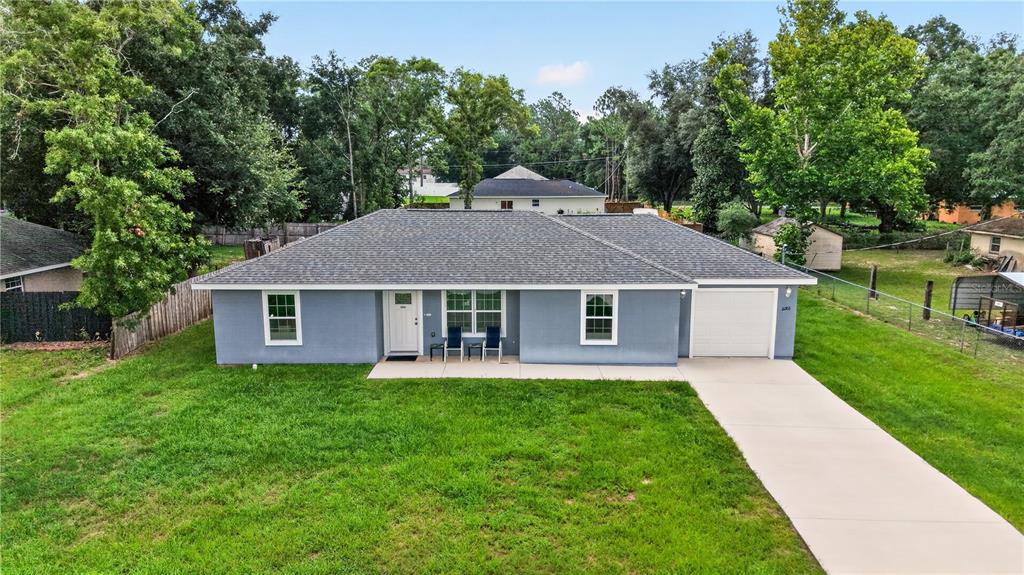 A single-story gray house with a white garage door and a concrete driveway — 12203 SE 87TH COURT, BELLEVIEW, FL