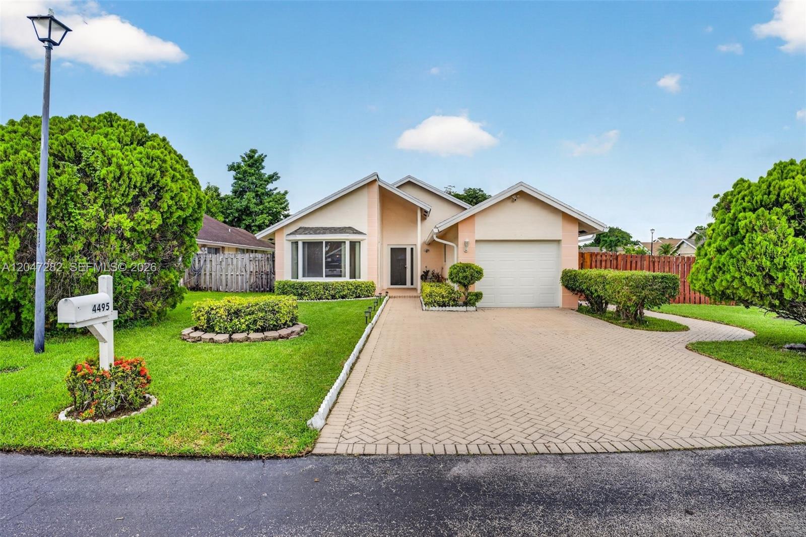 A single-story house with a paved driveway, a garage, and a landscaped front yard — 4495 NW 99th Ave, Sunrise FL 33351, SUNRISE, FL