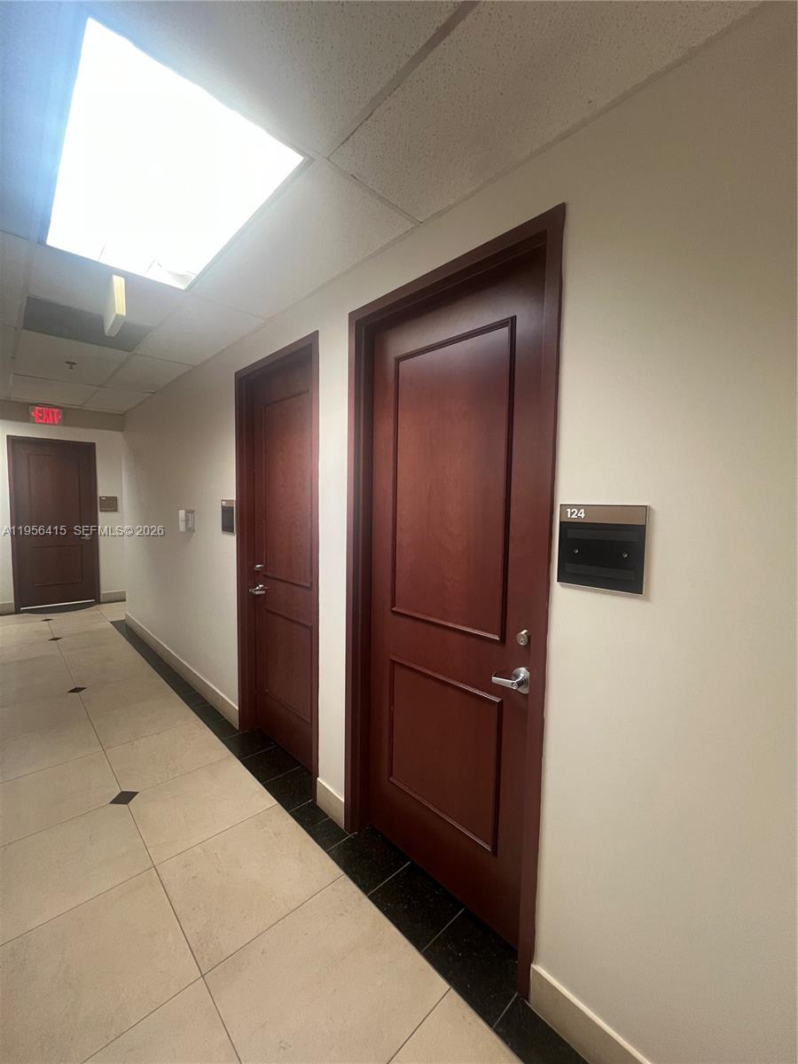 A hallway features light tile flooring, dark wood doors, and a sign for room 124 — 2893 Executive Park Dr # 125, Weston FL 33331, WESTON, FL
