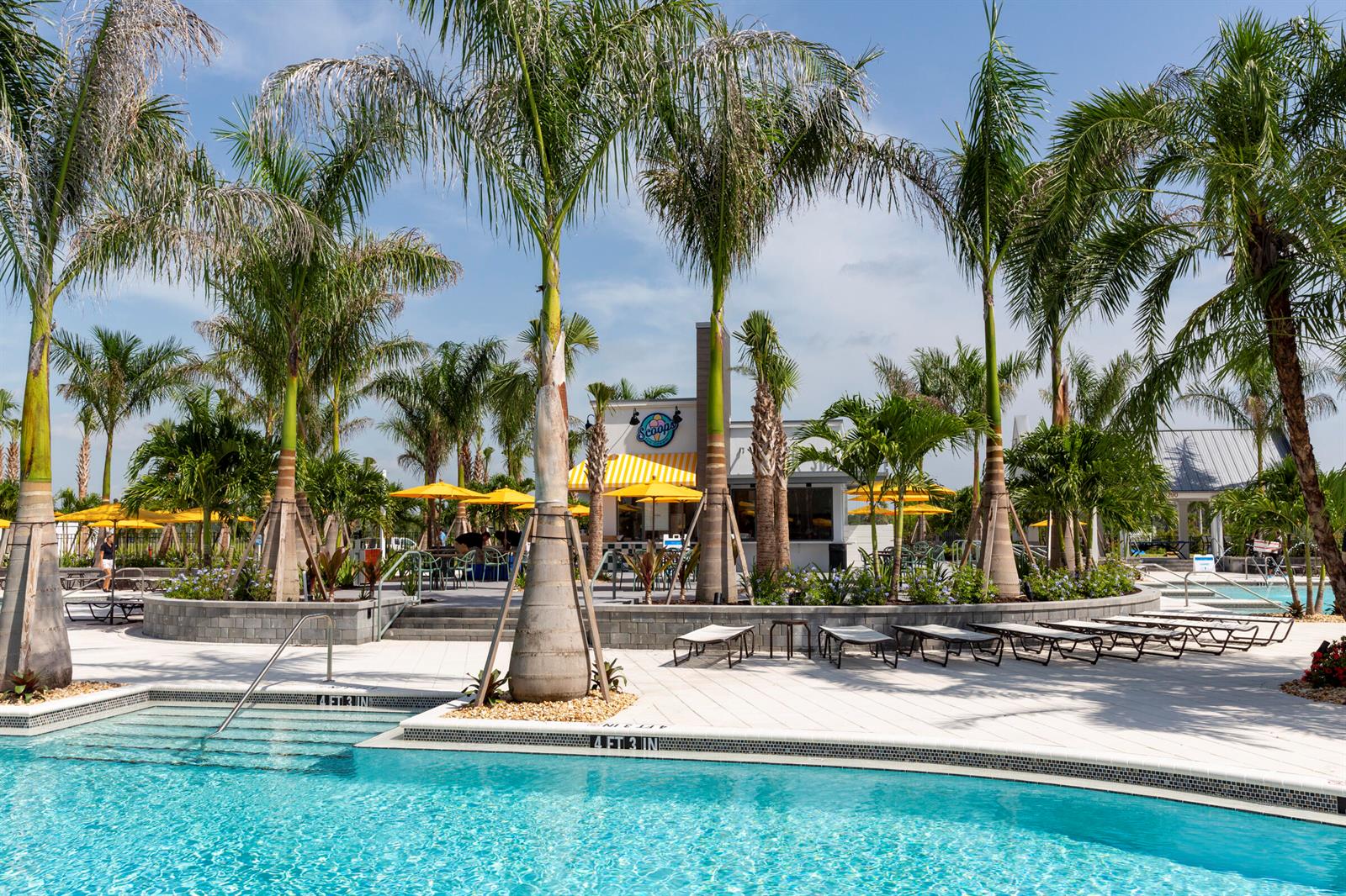 A swimming pool with lounge chairs and palm trees in front of a snack bar — 4506 Estates Circle, Westlake FL 33470, WESTLAKE, FL