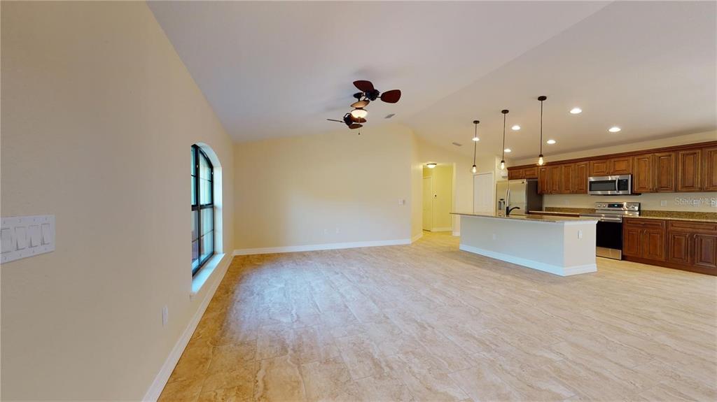 An open-concept kitchen and living area with tile flooring and a kitchen island — 2337 SIMONTON AVENUE, NORTH PORT, FL