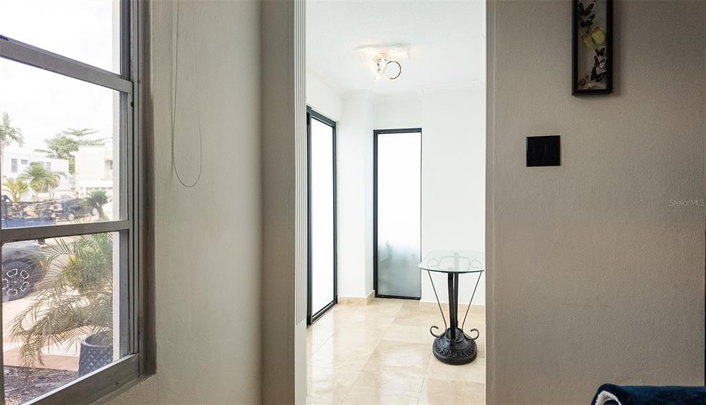 A view through a doorway shows a tiled entryway with a small glass table — 14 VIA CANGREJOS, TOA BAJA, PR