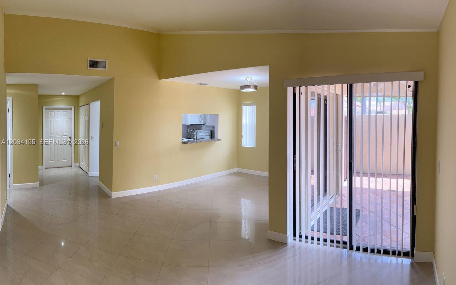 An interior view shows a living area with tile floors, yellow walls, and sliding doors — 6361 NW 170th Ln, Hialeah FL 33015, HIALEAH, FL