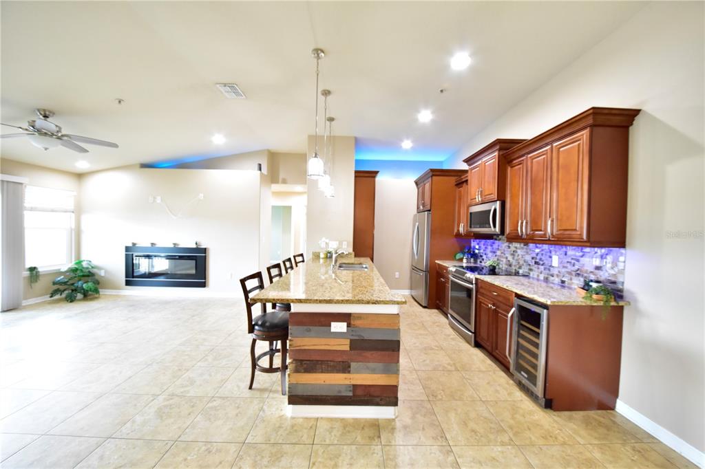 A kitchen with granite countertops and wood cabinets features a rustic pallet-style island base — 6420 BANYAN BOULEVARD UNIT 303, NEW PORT RICHEY, FL