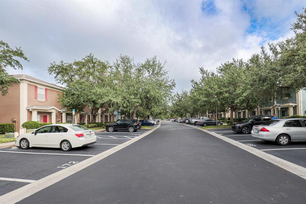 A paved parking lot lined with cars sits between two rows of residential buildings — 3664 WILSHIRE WAY ROAD UNIT 261, ORLANDO, FL