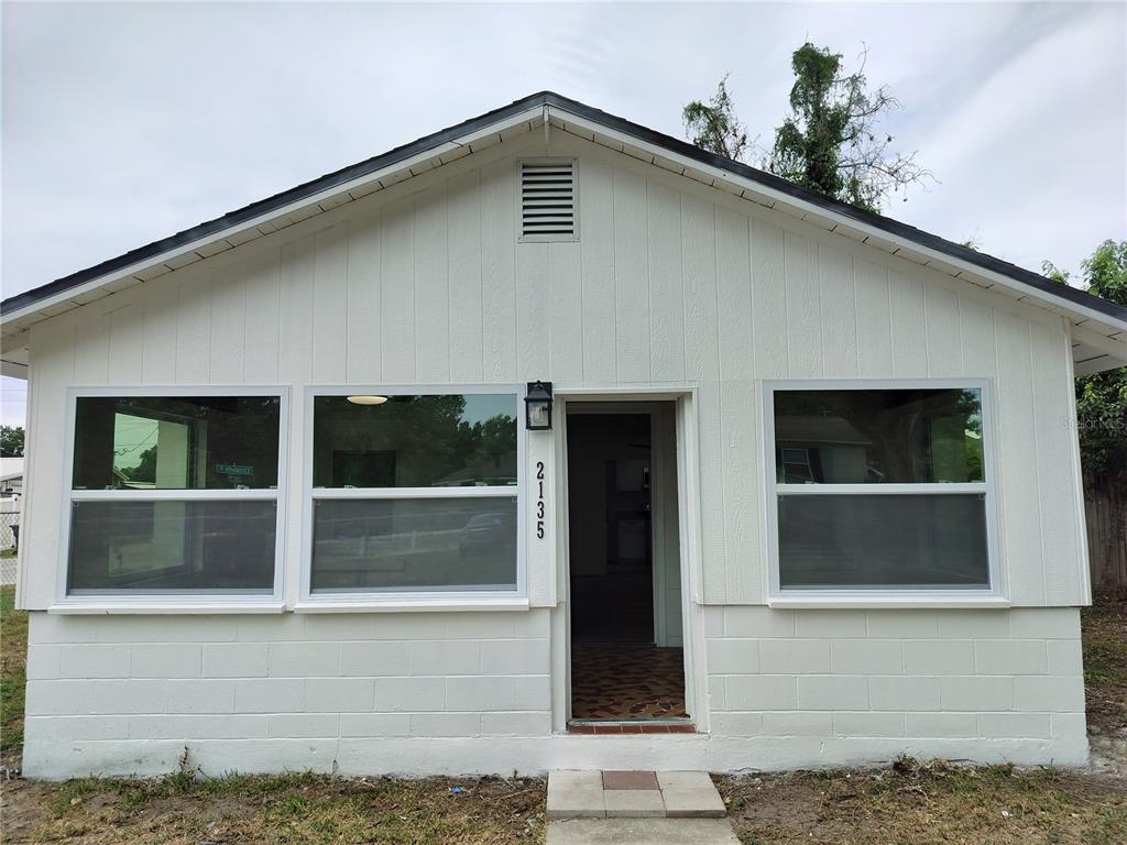 A white, single-story house exterior features three windows, a central doorway, and a gable roof — 2135 ELIZABETH STREET, LAKELAND, FL