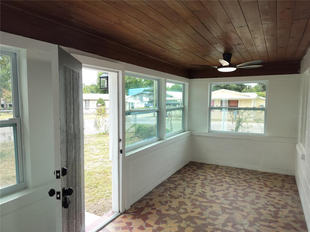 A sunroom features a wood-plank ceiling, a ceiling fan, and patterned tile flooring — 2135 ELIZABETH STREET, LAKELAND, FL