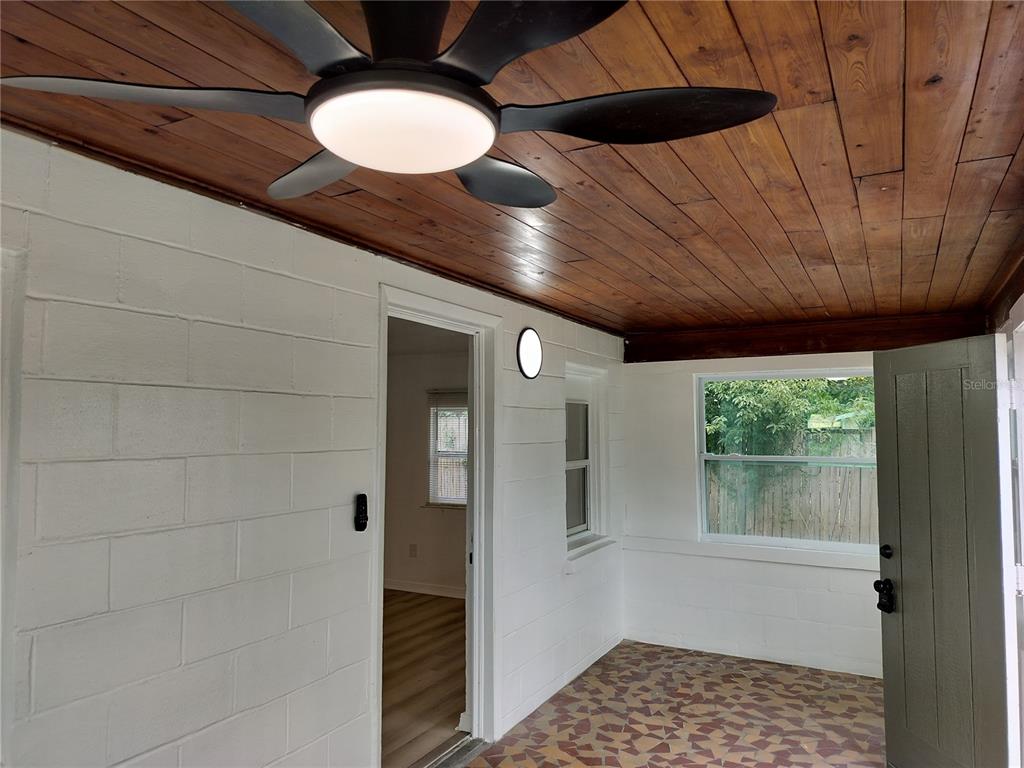 A covered porch with a wood-plank ceiling, white block walls, and a patterned tile floor — 2135 ELIZABETH STREET, LAKELAND, FL