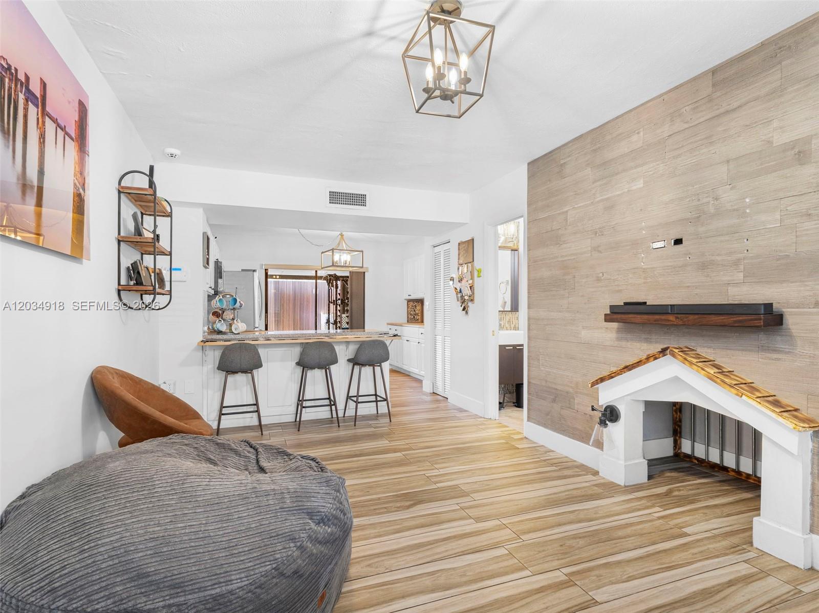 A living area features wood-look tile flooring, a decorative fireplace, and an open kitchen — 1805 SW 107th Ave # 2601, Miami FL 33165, MIAMI, FL