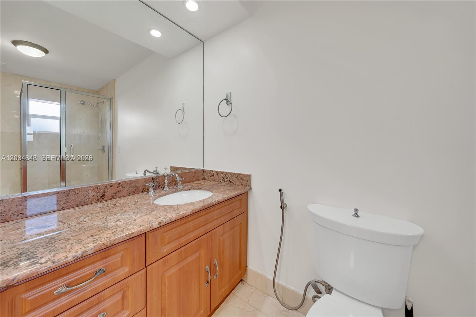 A bathroom features a wooden vanity with a granite countertop, a mirror, and a toilet — 7600 SW 19th Ter # C, Miami FL 33155, MIAMI, FL